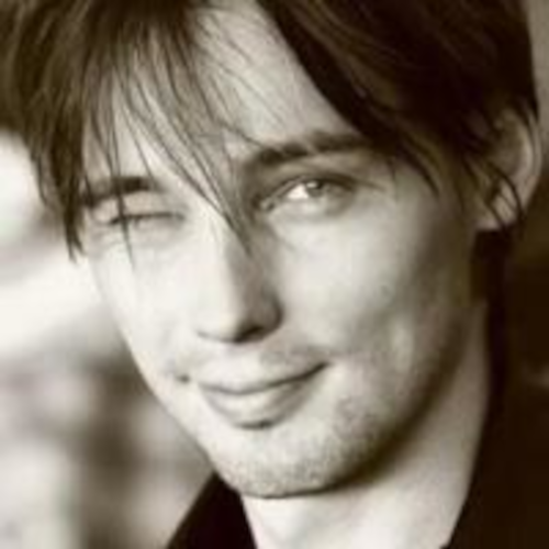 Profile Picture of Adrián Moreno (@zetxek), working side by side with a colleague: sitting on a desk, while looking at a screen